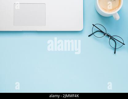 Flacher, sauberer Schreibtisch mit blauem Hintergrund Stockfoto