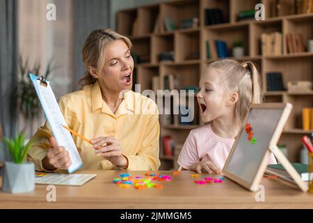 Sprachtraining für Kinder. Professionelle Fachausbildung mit dem kleinen Mädchen, die ihr die richtigen Artikulationsübungen beibringt Stockfoto