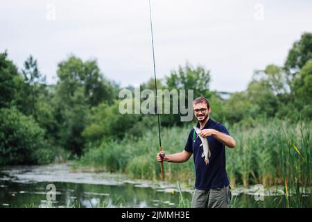 Mann, der Angelrute mit Fischhaken hält Stockfoto