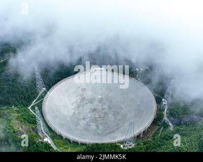 (220806) -- GUIZHOU, 6. August 2022 (Xinhua) -- Luftfoto vom 22. Juli 2022 zeigt Chinas fünfhundert Meter langes Aperture Spherical Radio Telescope (FAST), das in der südwestlichen Provinz Guizhou in Betrieb ist. Das Hotel befindet sich in einer natürlich tiefen und runden Karstniederlage in der südwestlichen chinesischen Provinz Guizhou und begann IM Januar 2020 MIT der offiziellen Operation und wurde am 31. März 2021 offiziell der Welt eröffnet. Es wird angenommen, dass es das empfindlichste Radioteleskop der Welt ist. Mit FAST haben Wissenschaftler über 660 neue Pulsare identifiziert. (Xinhua/Ou Dongqu) Stockfoto