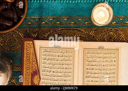 Nahaufnahme der Kerze in der Nähe des quran Stockfoto