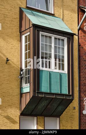 Münster, 28. Juli 2022: Farbenfrohe Szene mit einem Erker, der in einer Fassade aus Gips und Ziegel mit Zink verkalkt ist Stockfoto