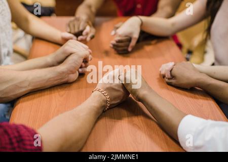 Anonyme Personen halten sich die Hände Stockfoto