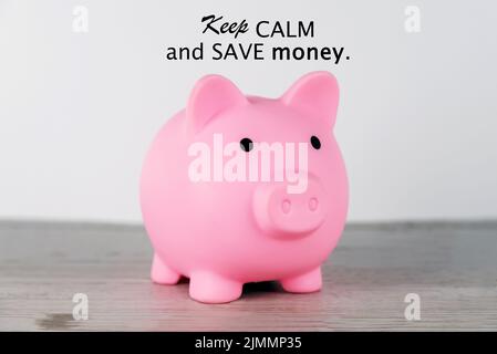 Finance inspirierende motivierende Zitat - Halten Sie Ruhe und Geld sparen. Mit rosa Sparschwein auf dem Tisch auf weißem Hintergrund. Finanzplanungskonzept. Stockfoto