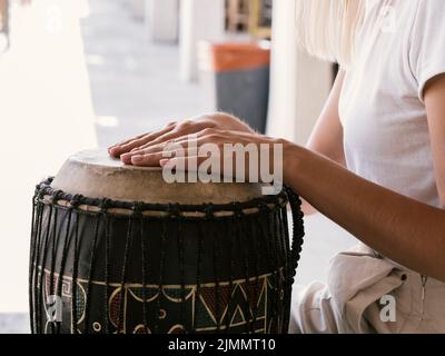 Junge Person, die ein lateinisches Schlagzeuginstrument spielt Stockfoto