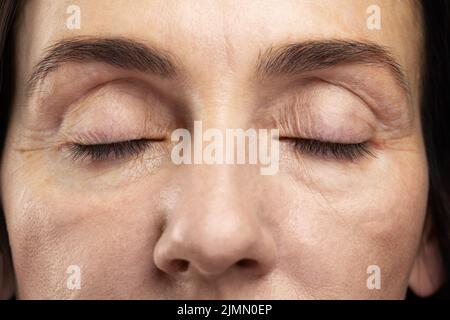 Müde Augen einer Frau mittleren Alters Stockfoto