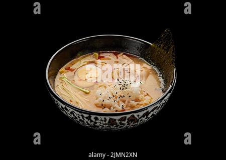 Kimchi-Tige-Suppe in einem tiefen Gericht auf einem schwarzen isolierten Hintergrund Stockfoto