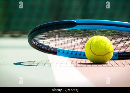 Tennisschläger und Ball liegen auf dem Platz. Gesundes Lifestyle-Konzept Stockfoto