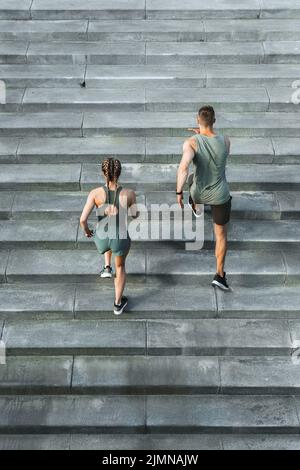 Sportliches Paar beim Training, Treppenlauf im Freien Stockfoto