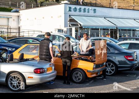 Autokreuzfahrt in Southend on Sea, Essex, Großbritannien, am Abend nach einem heißen Sommertag. Der klassische Ford Fiesta Mk.1 zieht außerhalb von Rossi's Aufmerksamkeit auf sich Stockfoto