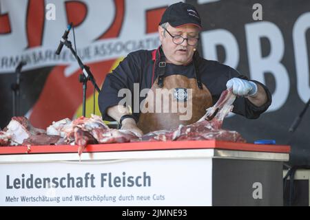 07. August 2022, Hessen, Fulda: Fleisch wird an einem Stand der Deutschen Grill- und BBQ-Meisterschaft 25. zubereitet. Die Meisterschaft fand vom 6. Bis 7. August 2022 in Fulda statt. Profis und Amateuren wetteiferten um den Sieg. Die Branche präsentierte sich mit verschiedenen Ständen und Veranstaltungen. Foto: Hannes P. Albert/dpa Stockfoto