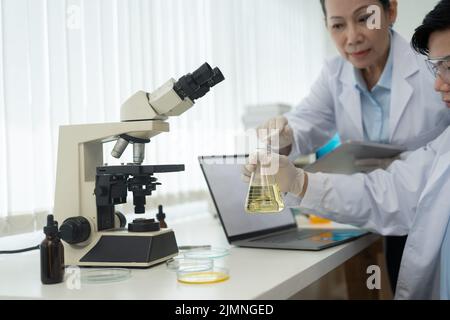 Science Oil Chemistry Expertise ist Experimentanalyse mit Mikroskopgeräten im Labor. Doppelte Exposition bei chemischen Forschungstests des Wissenschaftlers Stockfoto