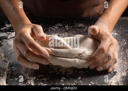 Spitzenköche kneten Teig mit den Händen Stockfoto