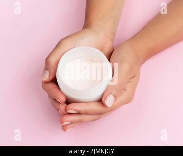 Frau mit Gesichtscreme-Box Stockfoto