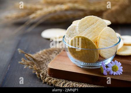 Round Cracker Kekse in Glas-Tasse und Holz Hintergrund, Dry Cracker Cookies, Snack-und Fast-Food-Konzept Stockfoto