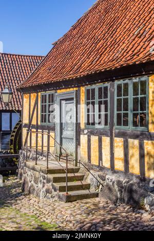 Gepflasterte Straße mit einem historischen Fachwerkhaus in Aarhus, Dänemark Stockfoto