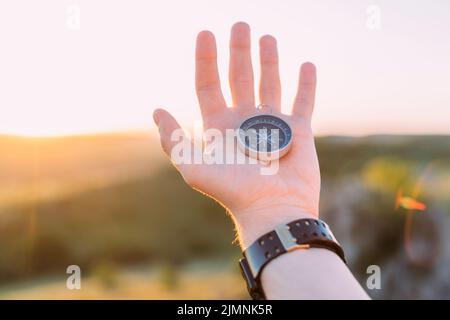 Die Hand der Person hält den Kompass Stockfoto