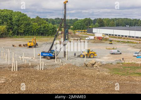 Ansicht der Baumaschinen, die gerade in Bearbeitung sind, der Anfahrstapel im Baubereich. Schweden. Enkoping. Stockfoto