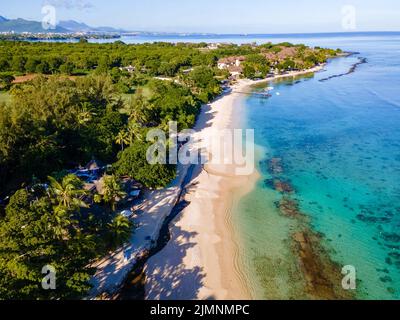 Drohnenansicht eines tropischen Strandes, Männer und Frauen, die auf Mauritius an einem tropischen Strand spazieren Stockfoto