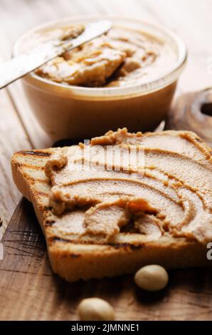 Low-Winkel-Ansicht Erdnussbutter Sandwich auf Schneidbrett mit Toasts beiseite. Gesundes Essen Konzept Stockfoto