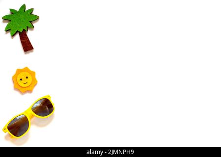 Gelbe Sonnenbrille, Sonne, Palme auf weißem Hintergrund. Platz kopieren. Stockfoto