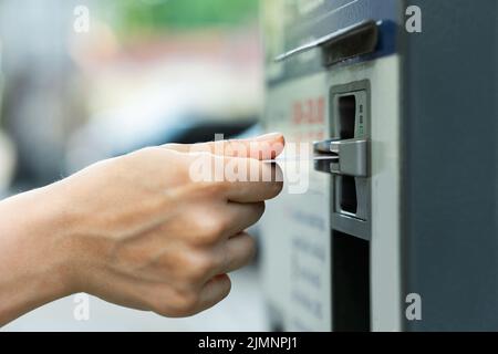 Weibliche Hand mit Kreditkarte und Ticketautomaten Stockfoto