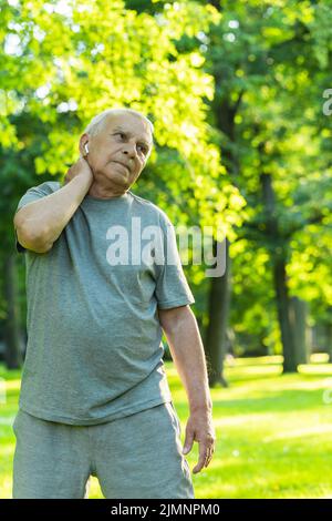 Älterer Mann, der während seines Fitnesstrainings im grünen Stadtpark trainiert Stockfoto