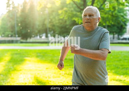 Älterer Mann während seines Jogging-Trainings in einem Stadtpark Stockfoto