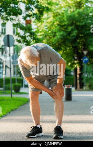 Älterer Mann, der während seines Jogging-Trainings an Knieschmerzen litt Stockfoto