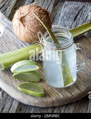 Kokoswasser mit Aloe Vera Stücken in einem Glas, fertig zum Trinken. Stockfoto