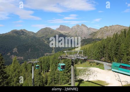 San Martino di Castrozza, TN, Italien - 2. August 2022: Landschaft und Seilbahn oder CABINOVIA in italienischer Sprache Stockfoto