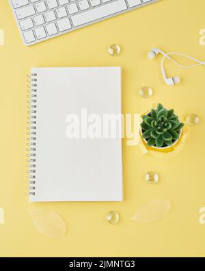 Leere Notizblock-Seite in Bullet Journal auf hellgelben Büro-Desktop Stockfoto