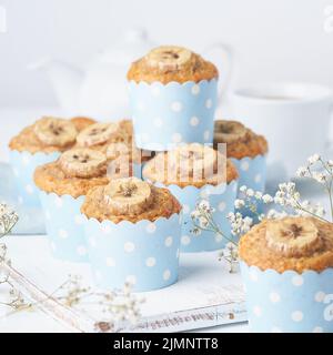 Bananenmuffin, Cupcakes in blauen Kuchenhüllen Papier, Seitenansicht. Frühstück auf weiß Stockfoto