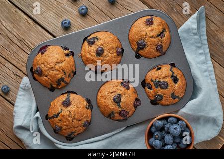 Blaubeer Muffin im Tablett, Draufsicht. Cupcakes mit Beeren in Backform Stockfoto