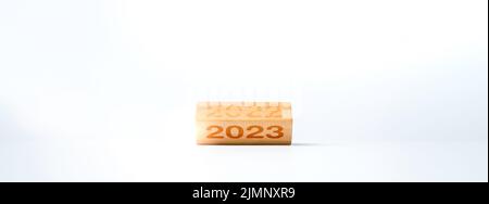 2023 Happy New Year Concept Banner. Den Kalender mit 2022 bis 2023 Jahreszahlen auf hölzernen Würfelblöcken spiegeln, die auf weißem Hintergrund für das neue Jahr ch isoliert sind Stockfoto