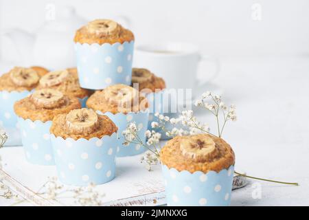 Bananenmuffin in blauen Kuchenhüllen, Papier, Seitenansicht, Nahaufnahme, Kopierraum. Frühstück am Morgen Stockfoto