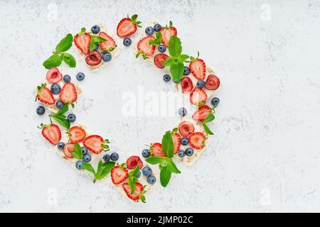 Rise Knäckebrot Rahmen mit Beeren und Früchten farbenfrohe Konzept auf Pastellfarben Hintergrund Stockfoto