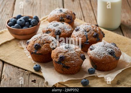 Blaubeer Muffin, Seitenansicht. Cupcakes mit Beeren auf alter Leinenserviette Stockfoto