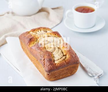 Ganze Bananenbrot, Kuchen mit Banane. Das Frühstück am Morgen auf hellgrauem Hintergrund Stockfoto