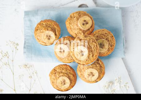 Bananenmuffin, Draufsicht, Nahaufnahme. Frühstück am Morgen auf blauer Serviette Stockfoto