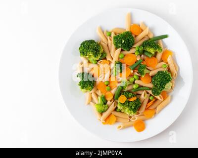 Vollkornteigwaren Penne mit Brokkoli, Karotten, grünen Erbsen. Kopierbereich, Draufsicht. Diätmenü Stockfoto