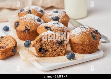 Blaubeer Muffin, Seitenansicht, Nahaufnahme. Cupcakes-Sektion mit Beeren auf weißem Betontisch Stockfoto