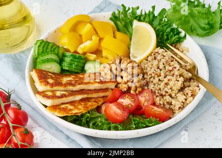 Buddha-Schüssel mit Halloumi, Quinoa, Salatsalat, vegeterischem Essen, weißem Hintergrund, Draufsicht Stockfoto