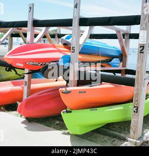 Farbenfrohe Kajaks auf einem Rack in der Nähe des Strandes an einem Sommertag Stockfoto
