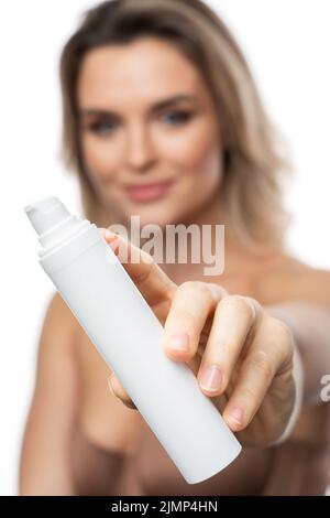 Schöne Frau mit einer weißen Flasche Kosmetik Stockfoto