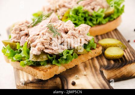 Hausgemachte Thunfisch salat Sandwiches auf Schneidebrett mit Essiggurken beiseite Stockfoto