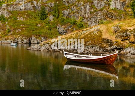 Die malerische Küste des Gebirgssees von Norwegen in der Nähe der Lofoten-Inseln, Fischerboote, die Hänge der Berge covere Stockfoto