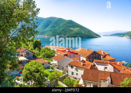 Redroof Häuser in Kotor mit Blick auf das Meer und die Berge Stockfoto