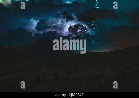 Riesiger Blitzschlag während des nächtlichen Gewitters in den Dolomiten. Italien, Dolomiten. Stockfoto