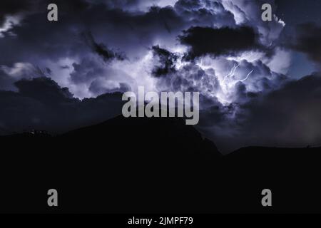 Riesiger Blitzschlag während des nächtlichen Gewitters in den Dolomiten. Italien, Dolomiten. Stockfoto